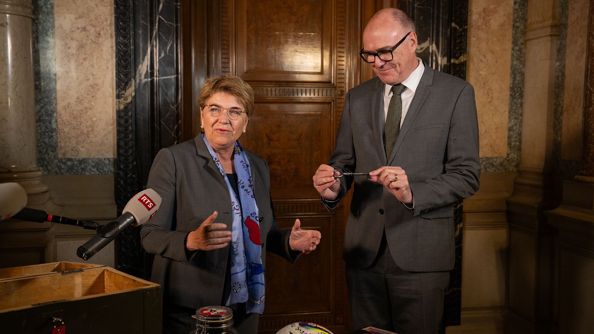 Bundesrätin Viola Amherd übergibt ihrem Amtsnachfolger Martin Pfister im Bundeshaus Ost symbolisch den Schlüssel zu ihrem Büro