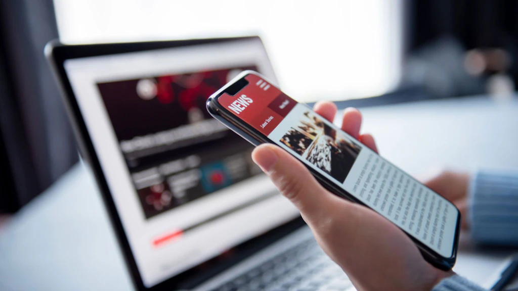 Online-Nachrichten auf Smartphone und Laptop.