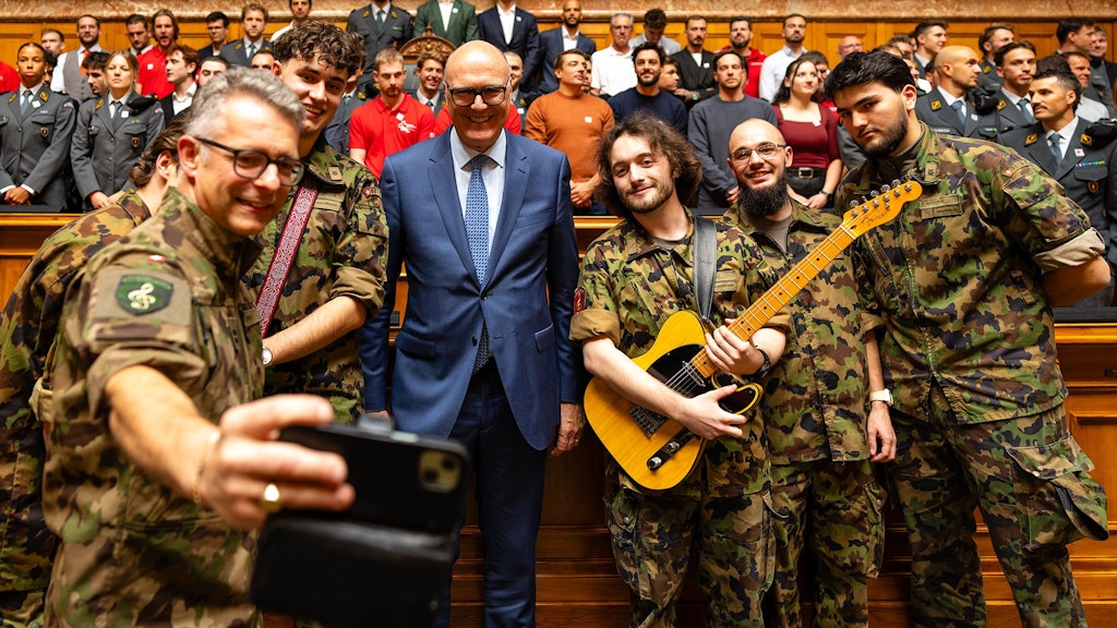 Bundesrat Martin Pfister posiert mit dem Ensemble der Militärmusik.