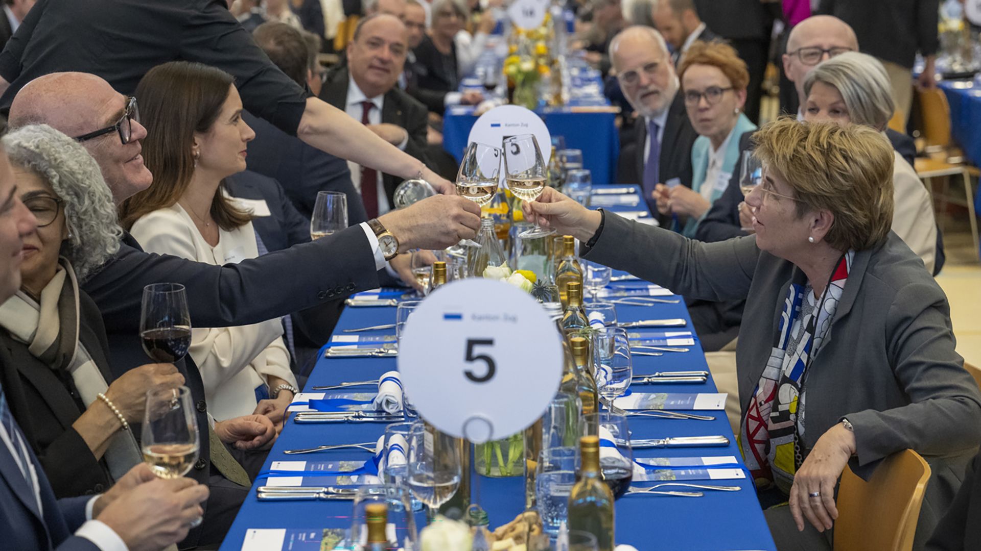 Martin Pfister und Viola Amherd stossen mit einem Glas Weisswein an.