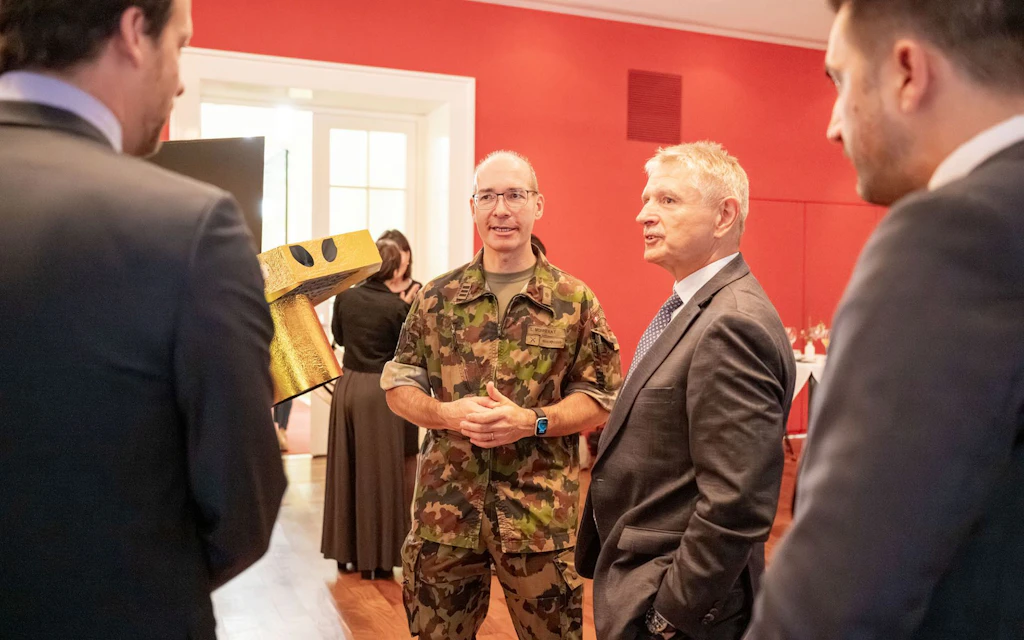 Des représentants de l’EPFZ, le conseiller aux États Charles Juillard et le colonel EMG Ludovic Monnerat discutent de la maquette du satellite.