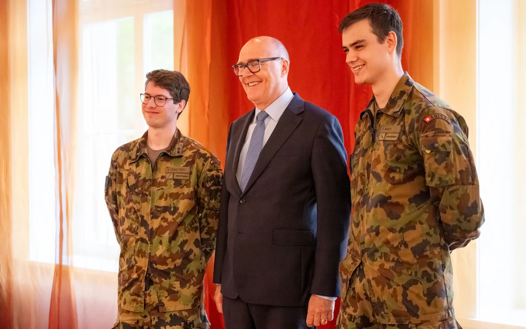 Le conseiller fédéral Martin Pfister pose lors du petit-déjeuner des parlementaires avec Jonas Troeltsch et Cyrill Marti, deux soldats de l'école de recrues Espace.